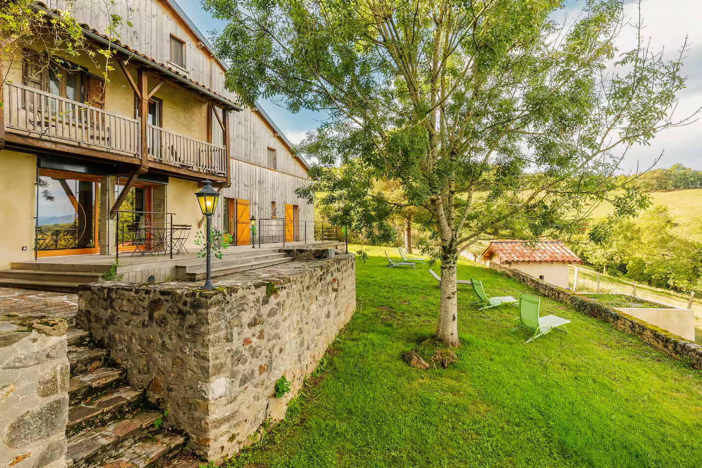 Façade en pierre du Gîte de Marbois avec terrasse et jardin en Ariège